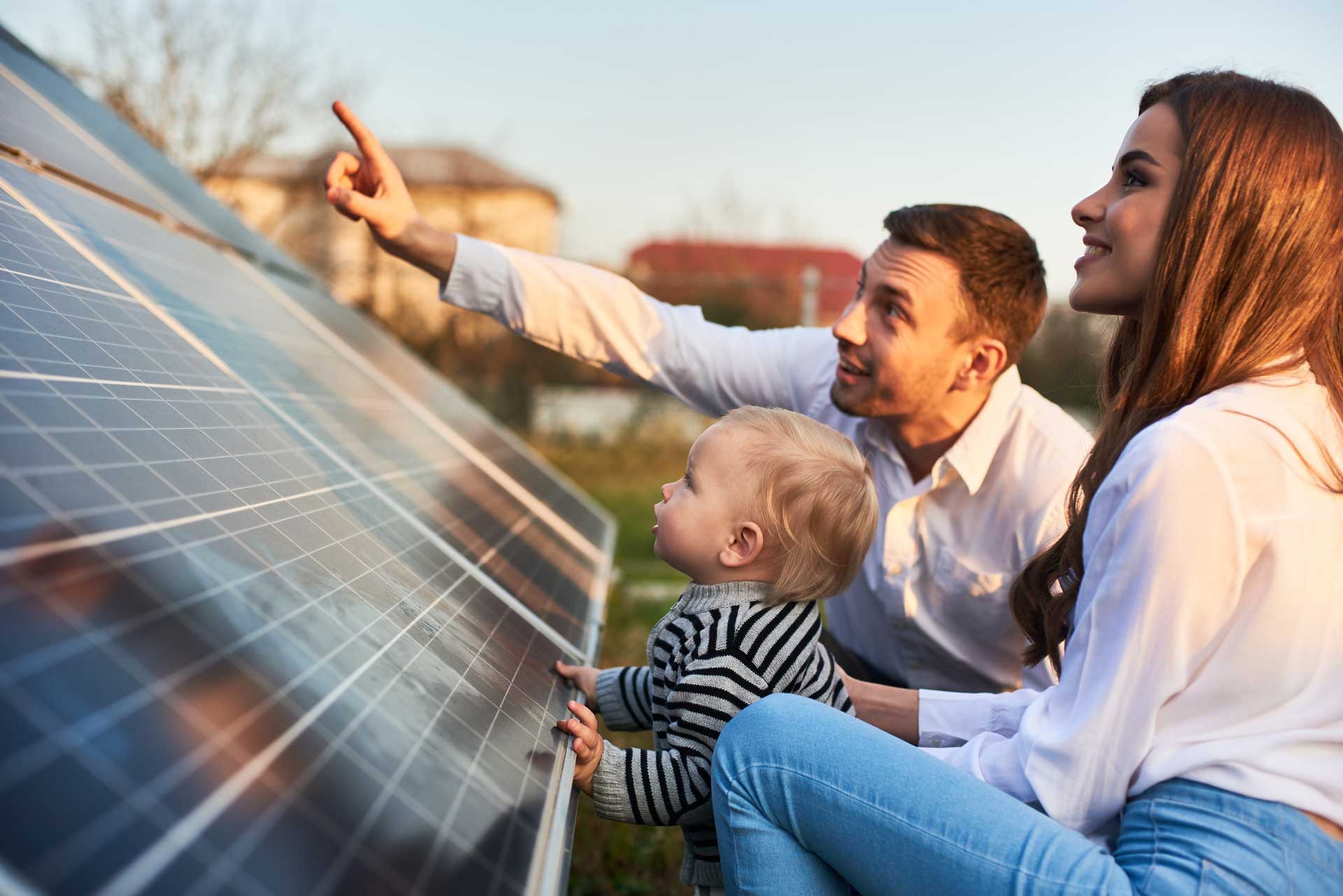 A family looking at a large solar panel