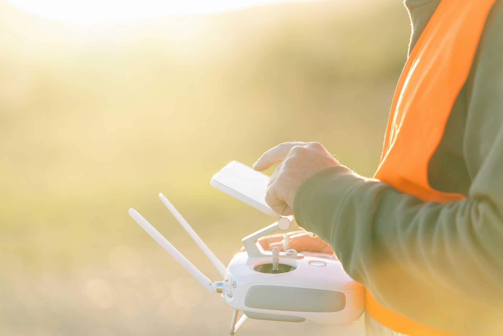 A drone pilot using their controller to pilot a drone